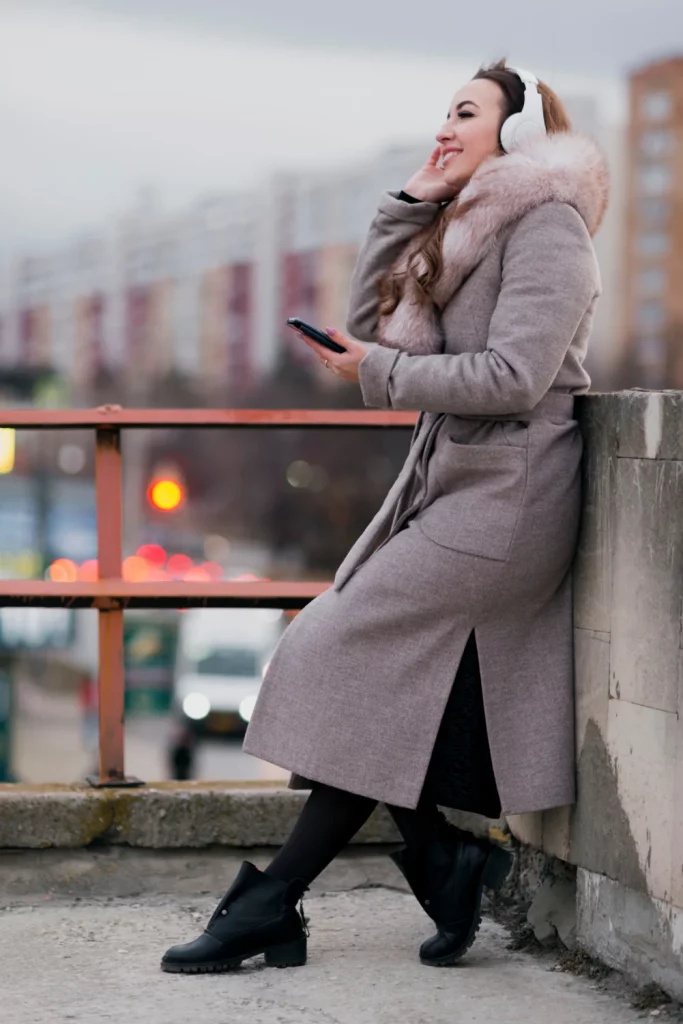 woman in heavy coat and wearing headphones.